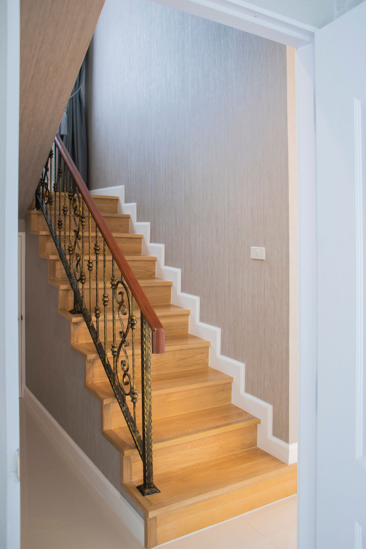 A finished oak staircase with a turned handrail
